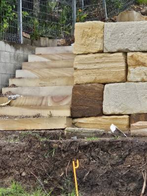 Sandstone steps being built into a retaining wall